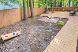 Backyard with cornhole and deck at Brandyapple Retreat, a Raleigh, NC vacation rental
