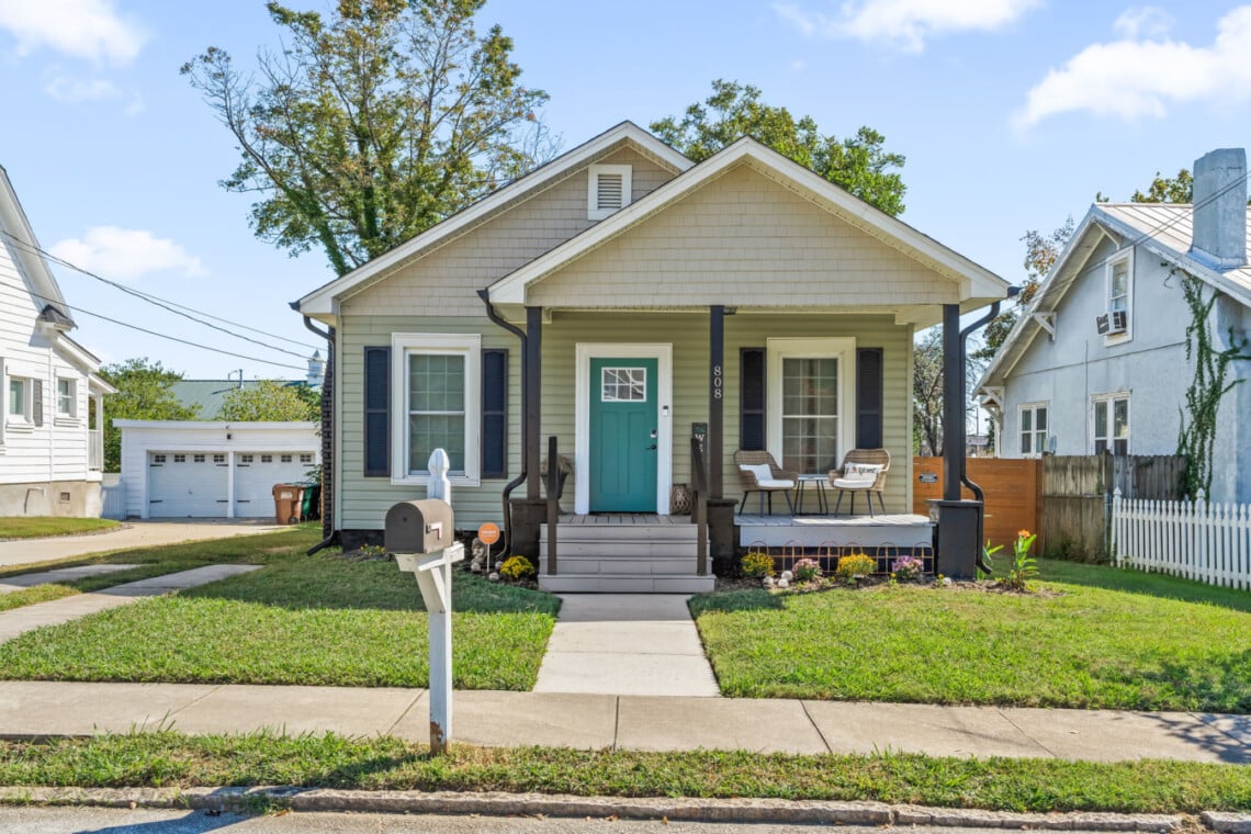 Front exterior of the blue bungalow with porch at Hygge High Point, a High Point, NC vacation rental