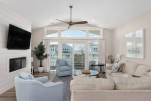 Living room with white armchairs and windows to the water
