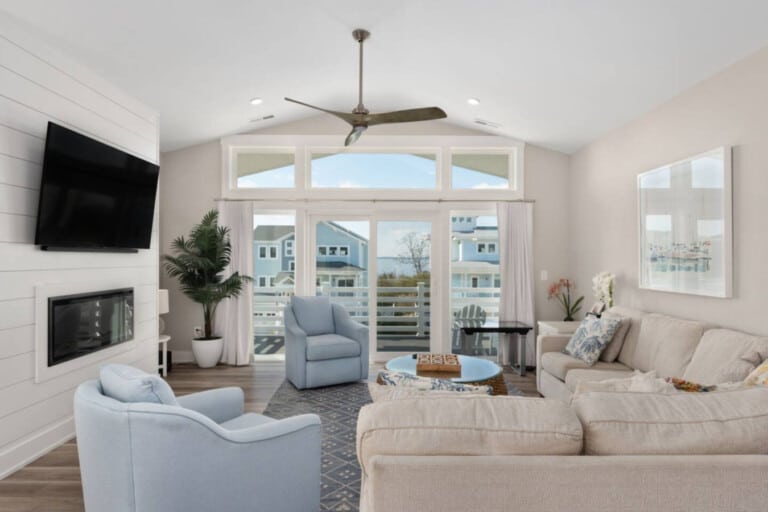Living room with white armchairs and windows to the water